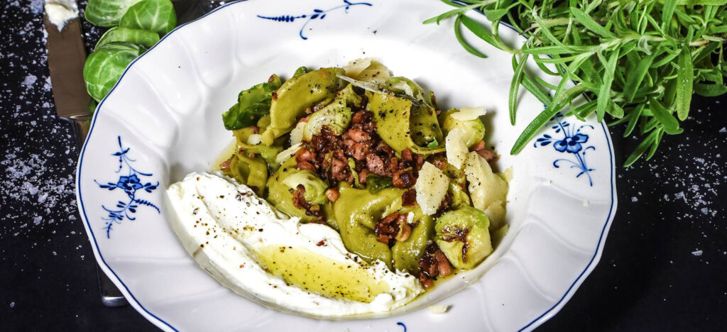 Recept på Spenat- och ricottafylld tortellini med tellicherrykorv, brysselkål och parmesan. Foto: Livets Goda